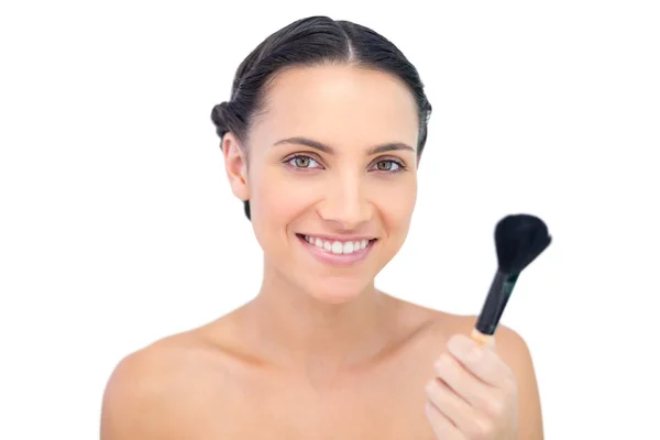 Smiling natural model holding a powder brush — Stock Photo, Image