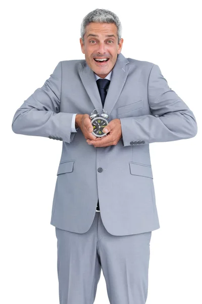 Cheerful businessman with alarm clock in both hands — Stock Photo, Image