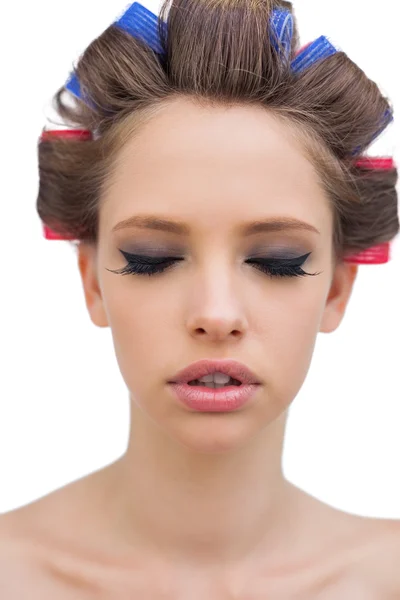 Pretty model with hair curlers closing eyes — Stock Photo, Image