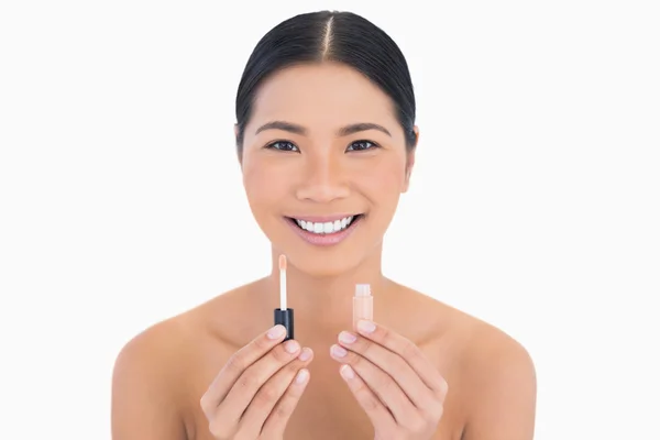 Smiling beautiful model holding lip gloss — Stock Photo, Image