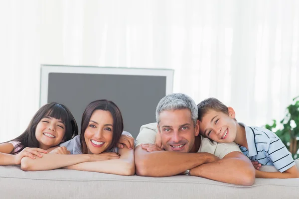 Söta familjen i vardagsrummet som ler mot kameran — Stockfoto