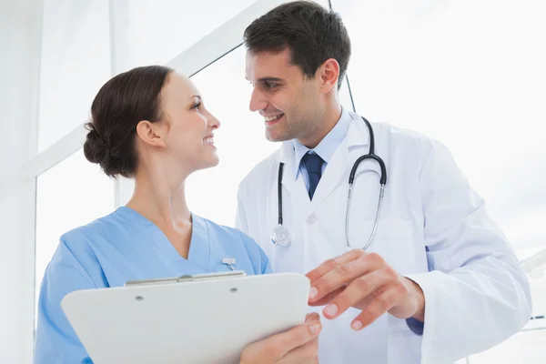 Cheerful doctor and surgeon looking at each other — Stock Photo, Image