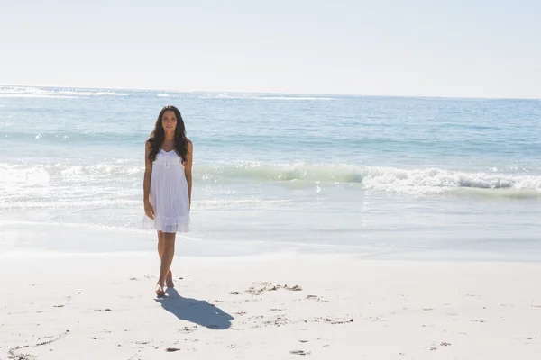 Hermosa morena en vestido de sol blanco caminando desde el mar — Foto de Stock