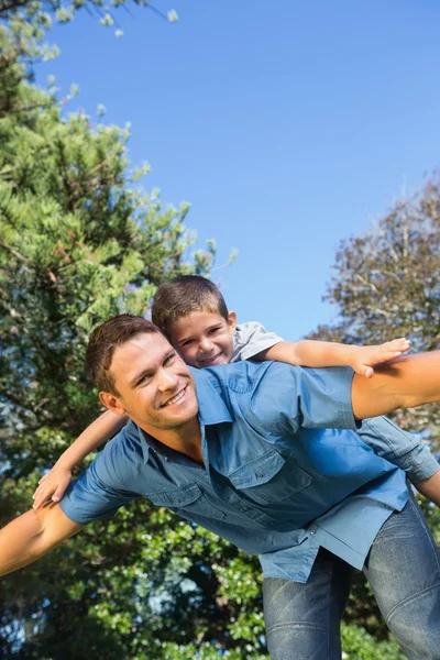 Son lying on his fathers back — Stock Photo, Image