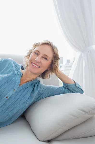 Content blonde woman relaxing on her couch — Stock Photo, Image