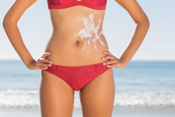 Вмістити жіноче тіло з сонячним кремом на животі — стокове фото