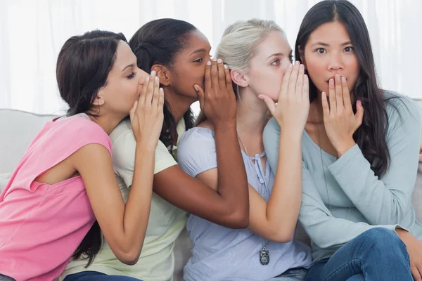 Friends whispering secret to shocked brunette — Stock Photo, Image