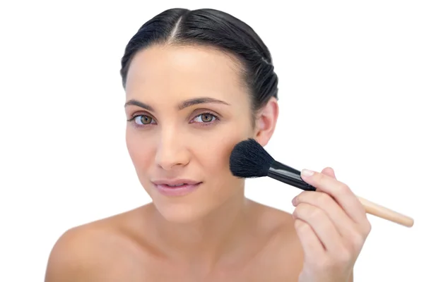 Hermosa modelo natural aplicando maquillaje en su cara — Foto de Stock