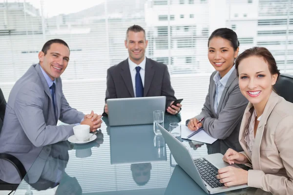 Glimlachende zakenmensen werken samen met hun laptop — Stockfoto