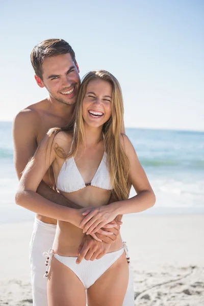Athletic couple smiling at camera and hugging — Stock Photo, Image