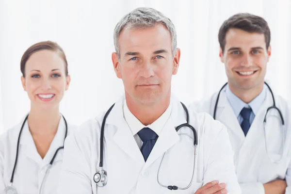 Médicos alegres posando juntos cruzando braços — Fotografia de Stock