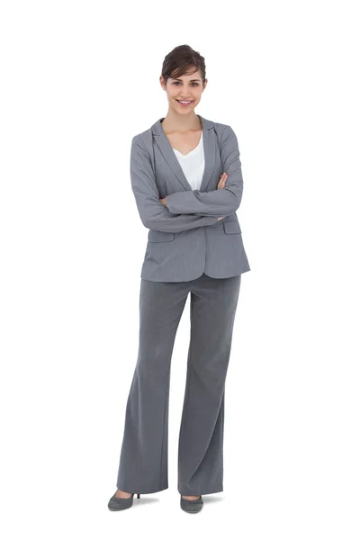 Jonge zakenvrouw met gekruiste armen glimlachen op camera — Stockfoto