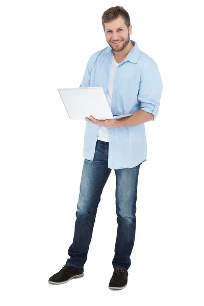 Hombre sonriente usando su portátil mirando a la cámara —  Fotos de Stock