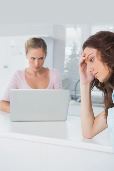 Mujer molesta pensando mientras su amigo enojado la mira —  Fotos de Stock