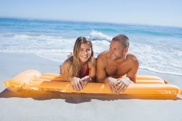 Cheerful cute couple in swimsuit lying on the beach — Stock Photo, Image