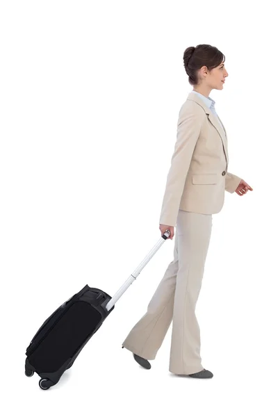 Serious businesswoman pulling suitcase — Stock Photo, Image