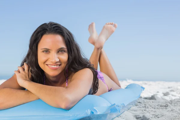 Sorrindo atraente morena deitada em seu lilo — Fotografia de Stock