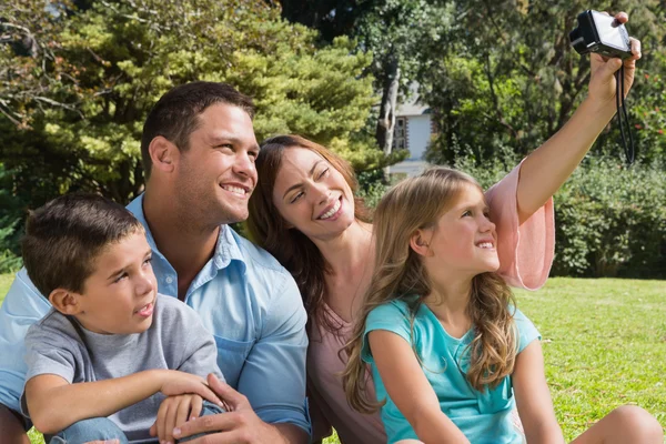 Happy family in a park taking photos — Stock Photo, Image