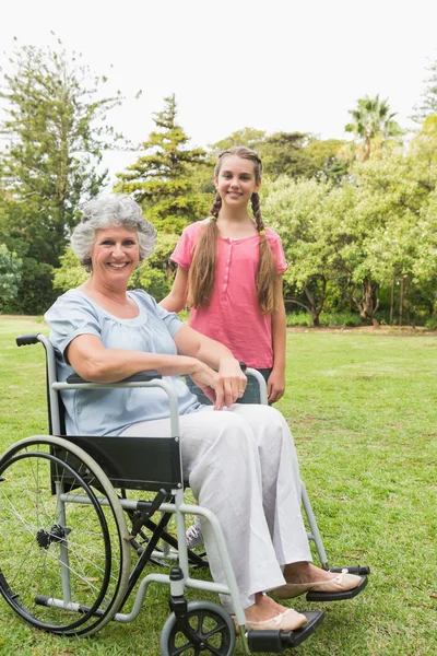 Lächelnde Enkelin mit Großmutter im Rollstuhl — Stockfoto