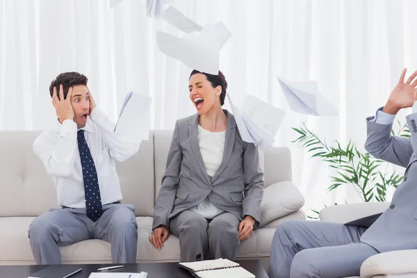 Empresários chocados com colega gritando e jogando papéis — Fotografia de Stock