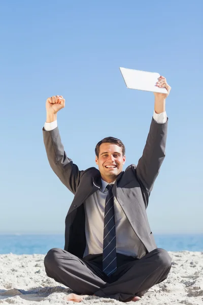 Victorious young businessman holding up his tablet computer — Stock Photo, Image