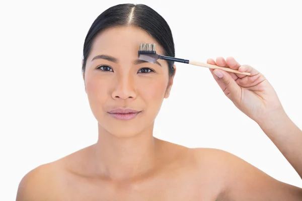 Peaceful gorgeous natural model using eyebrow brush — Stock Photo, Image