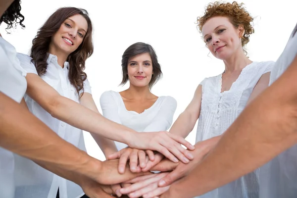 Cheerful models joining hands in a circle and looking at camera — Stock Photo, Image