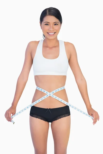Mulher magra alegre medindo sua cintura — Fotografia de Stock