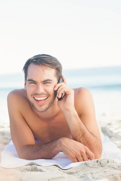 Uśmiechający się przystojny mężczyzna na plaży o telefon — Zdjęcie stockowe