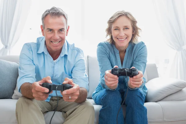 Joyeux couple jouant ensemble à des jeux vidéo sur le canapé — Photo