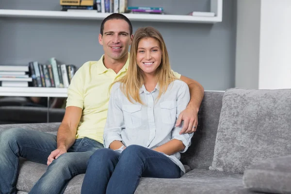 Feliz jovem casal sentado em seu sofá — Fotografia de Stock