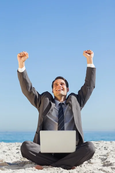 Victorious young businessman with his laptop — Stock Photo, Image