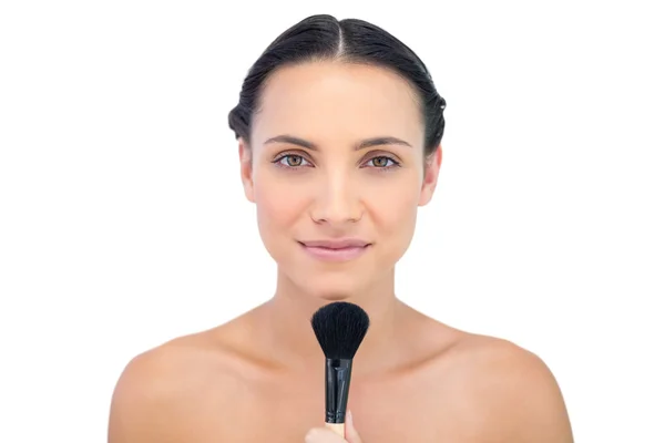 Friedliche natürliche Modell hält einen Make-up-Pinsel — Stockfoto