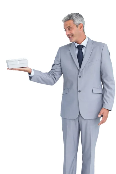 Hombre de negocios guapo sosteniendo regalo en la mano derecha —  Fotos de Stock