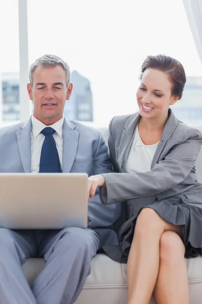 Smiling workmates working together sitting on sofa — Stock Photo, Image