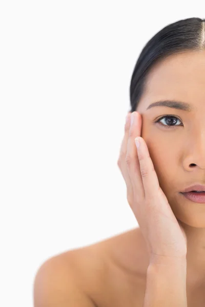 Half face of pensive natural model touching her cheek — Stock Photo, Image