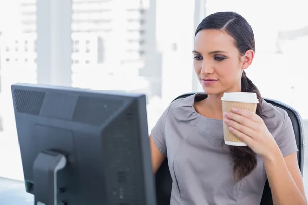Empresária atraente segurando café e trabalhando — Fotografia de Stock