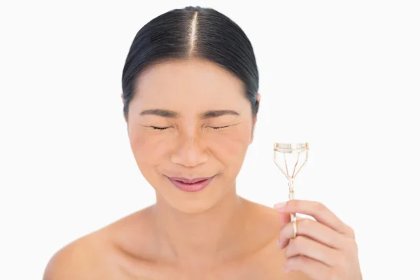 Fearful natural model holding eyelash curler — Stock Photo, Image