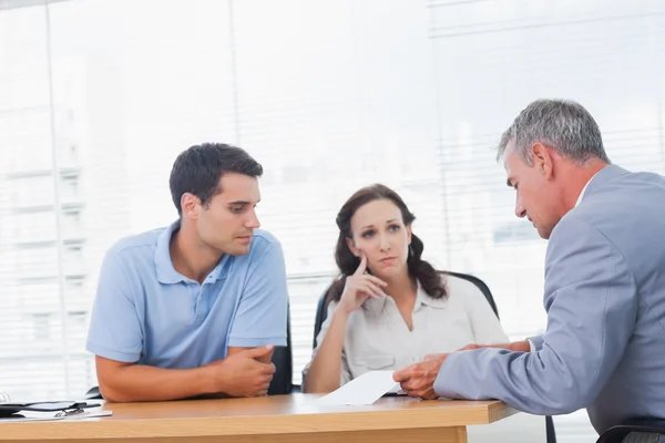 Ernstige paar onderhandelen met onroerende goederenagent — Stockfoto