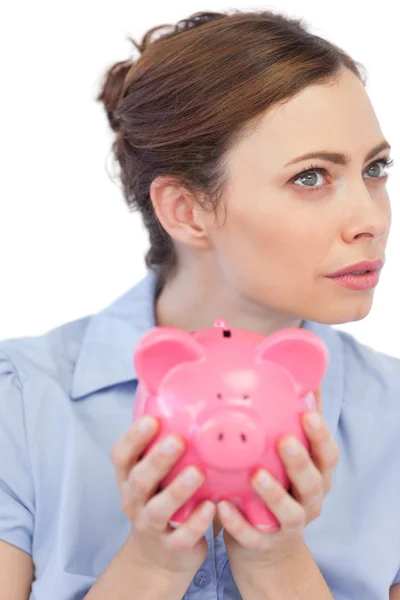 Thoughtful businesswoman posing with piggy bank in close up — Stock Photo, Image