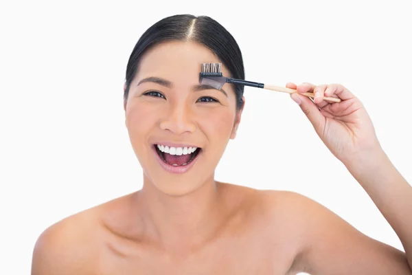 Laughing natural model using eyebrow brush — Stock Photo, Image