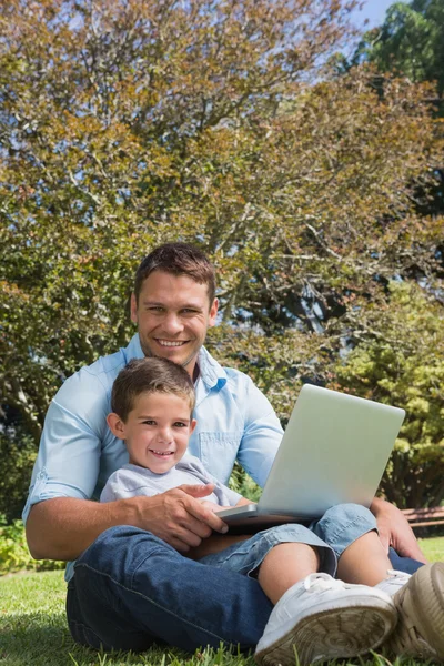 Attraktive Vater und Sohn lächelnd in einem Park — Stockfoto