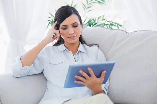 Doordachte brunette met tablet pc — Stockfoto