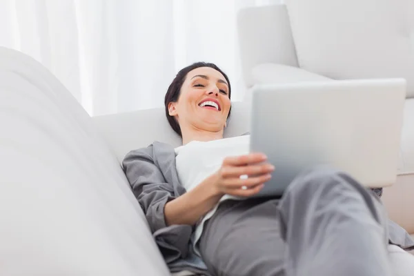 Ontspannen zakenvrouw liggend op de Bank met behulp van laptop — Stockfoto