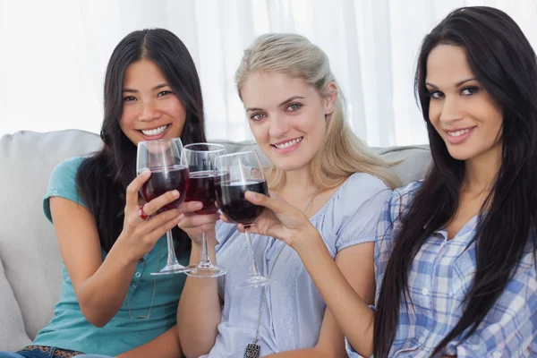 Felices amigos brindando con vino tinto juntos y mirando a la cam —  Fotos de Stock