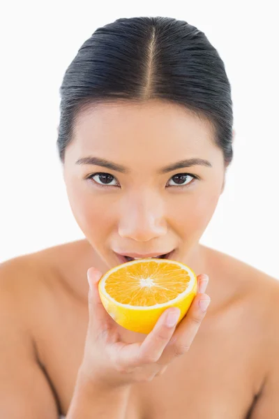 Mujer bonita mordiendo rebanada de naranja — Foto de Stock