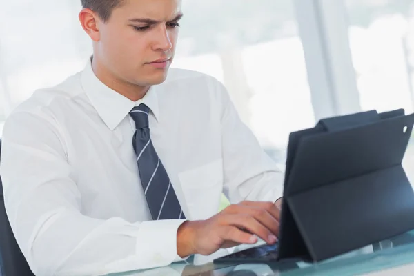 Ernstige jonge zakenman werken op zijn tablet pc — Stockfoto