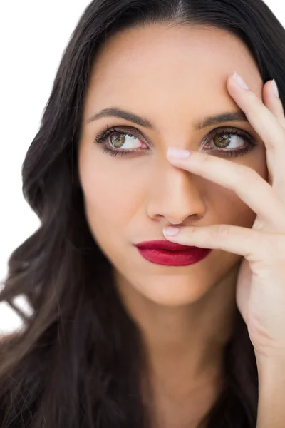 Thoughtful dark haired woman with red lips hiding her face — Stock Photo, Image