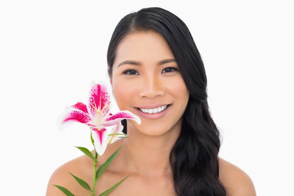 Uśmiechający się naturalne brązowe włosy modelu gospodarstwa lilia — Zdjęcie stockowe
