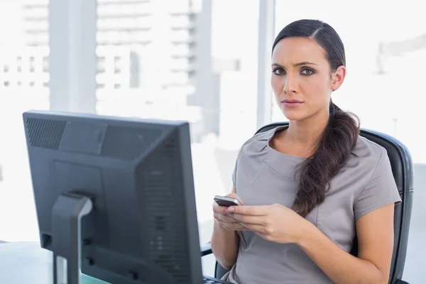 Anxious dark haired businesswoman sending message — Stock Photo, Image